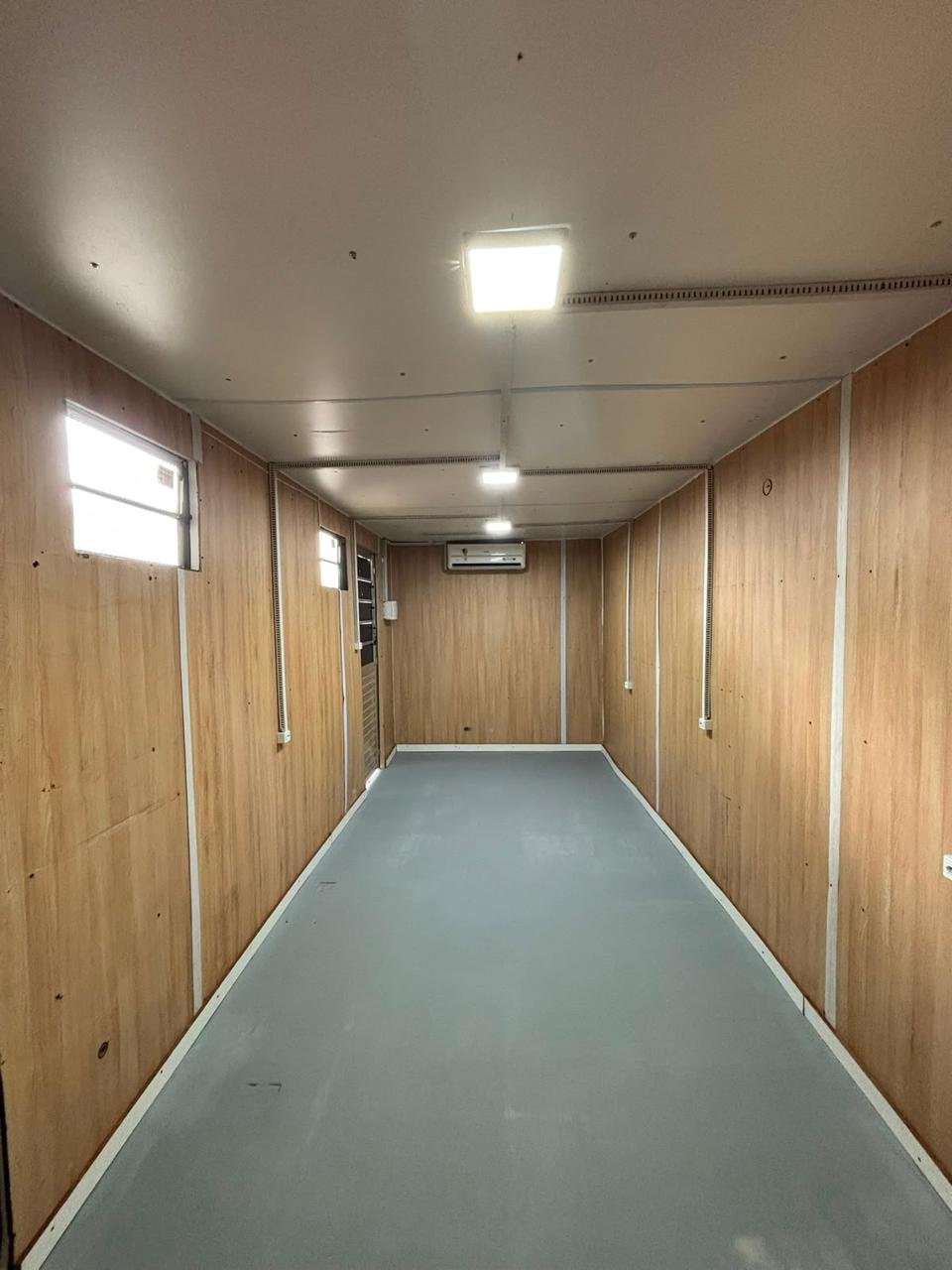 Interior de container adaptado como escritório, com acabamento e ar-condicionado